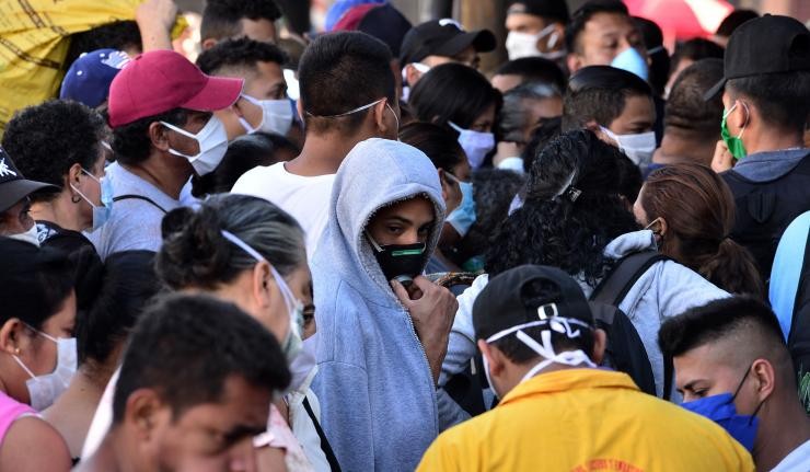 People in a crowded place standing wearing masks