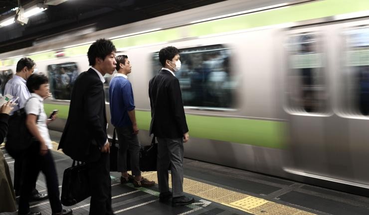 Passengers waiting to board Tokyo's metro