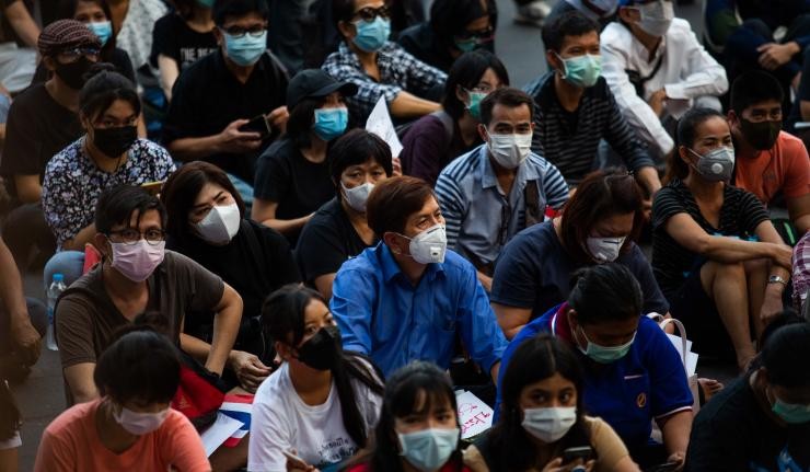 A crowded gathering of several individuals who are seated and wearing masks A crowded gathering of several individuals who are seated and wearing masks