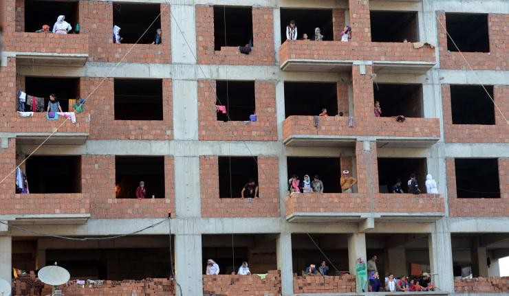 People living in a dilapidated red-brick building in Iraq