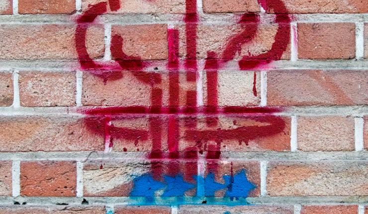 Graffiti on red brick wall presumably a symbol for nuclear proliferation