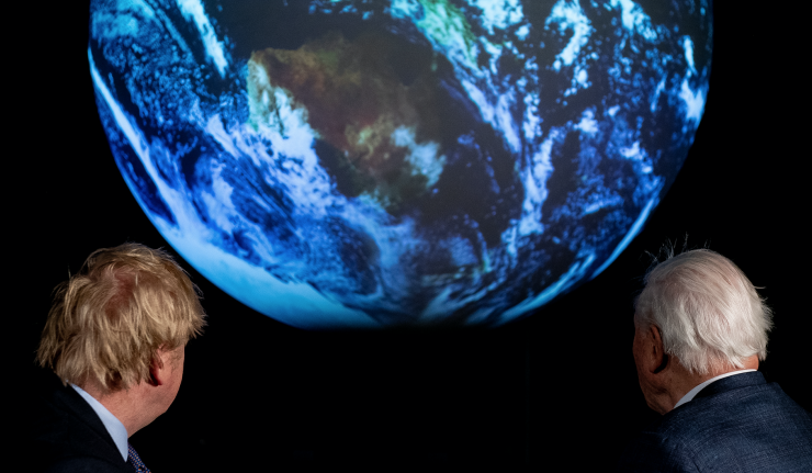 Boris Johnson and David Attenborough looking at a projection of the Earth