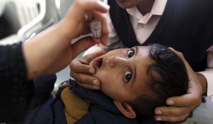 Child receiving a vaccine orally through a dropper