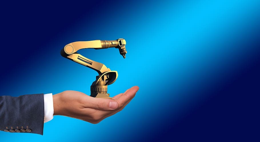 A robotic arm held on top of a human palm A robotic arm held on top of a human palm