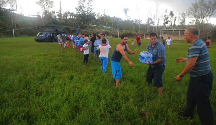 A human train transporting essential suppllies from a helicopter carrying relief to the land