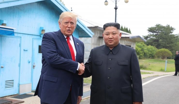 Donald Trump and Kim Jong Un shaking hands
