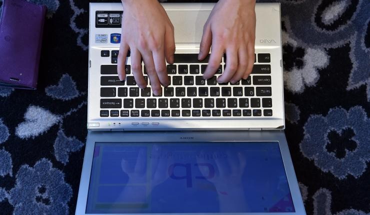 Pair of hands typing on a laptop