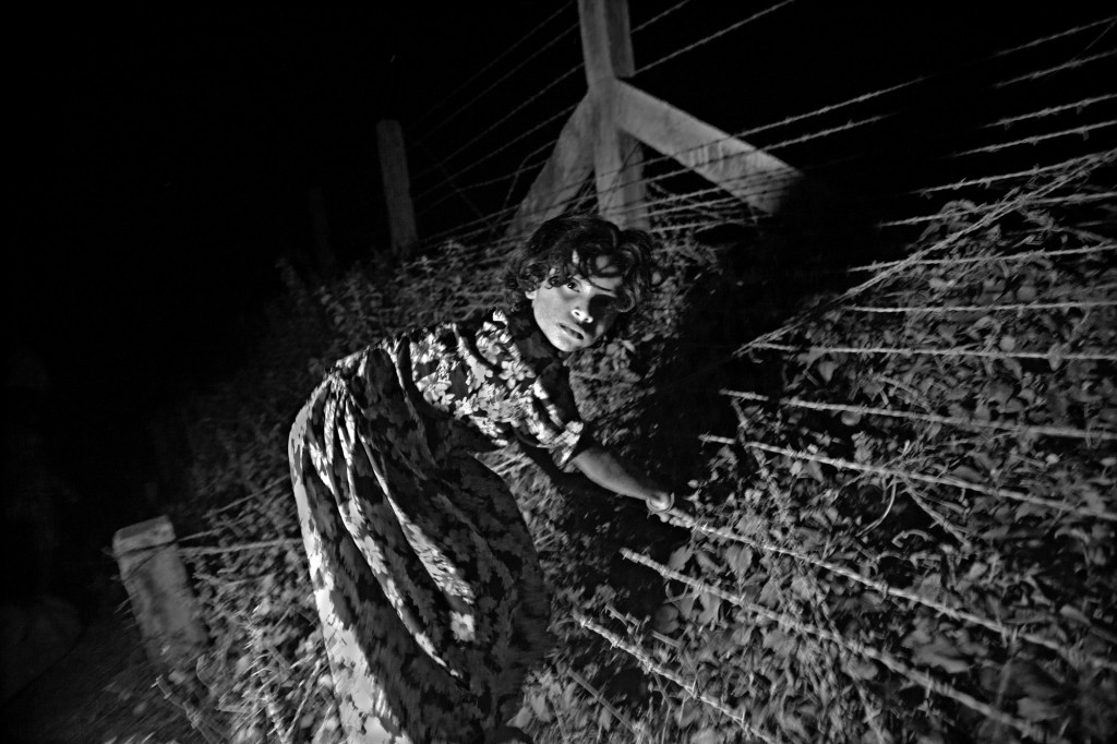 An 8-year-old girl crossing the border fence of Bangladesh and Burma. Her aunt was gang raped by the security forces three days before, and her family no longer felt safe in Burma. Eleven of them came to live in the unregistered camps the day after. An 8-year-old girl crossing the border fence of Bangladesh and Burma. Her aunt was gang raped by the security forces three days before, and her family no longer felt safe in Burma. Eleven of them came to live in the unregistered camps the day after.