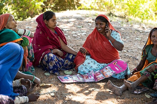 In Tegda Village, Sayra Block, Udaipur, Thavari, a community volunteer calls the Taruni Helpline after providing information on menstrual products and contraceptive choices to a women's group.