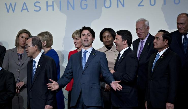 Justin Trudeau at a conference in Washington with arms oustretched