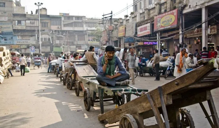 Man sitting on a bullock cart in a small Indian town
