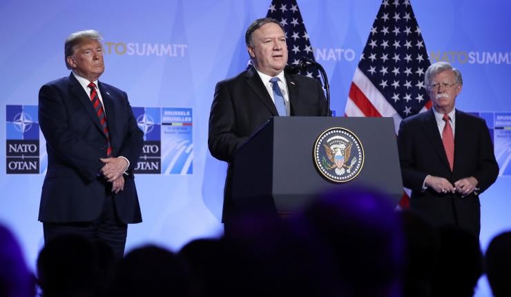 Mike Pompeo at the podium flanked by Donald Trump and John Bolton