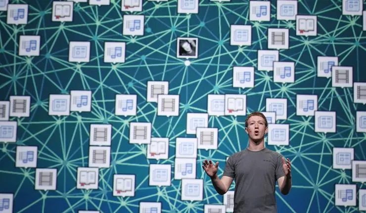 Mark Zuckerberg speaking to a live audience wearing a grey tshirt