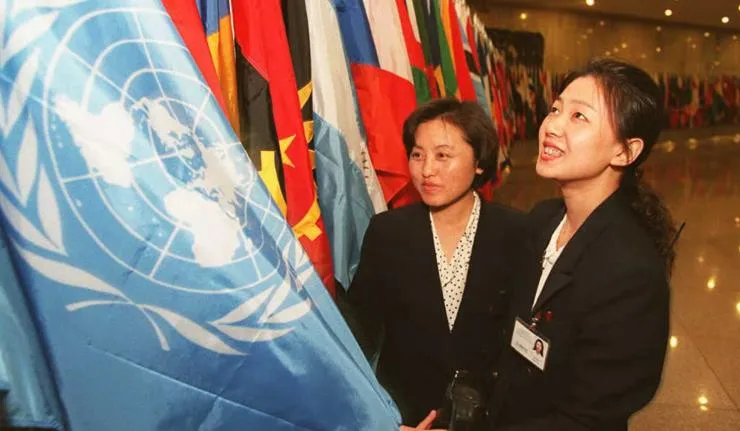 Students or UN officers looking at the UN flag