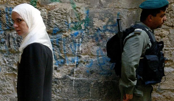 A soldier and a civilian at the West Bank border