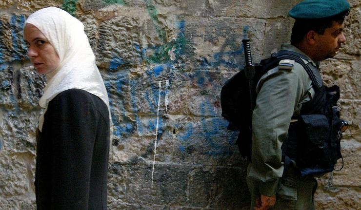 A soldier and a civilian at the West Bank border