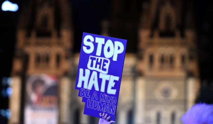 Protestor holding up signboard which says 'Stop the Hate: Be a Kind Human'