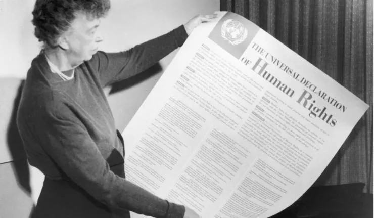 Woman holding up the Universal Declaration of Human Rights