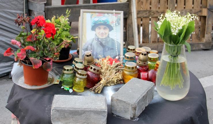 Tribute to a killed protestor in the Urkraine's Euromaidan revolution with Candles and Flowers placed against his framed photograph