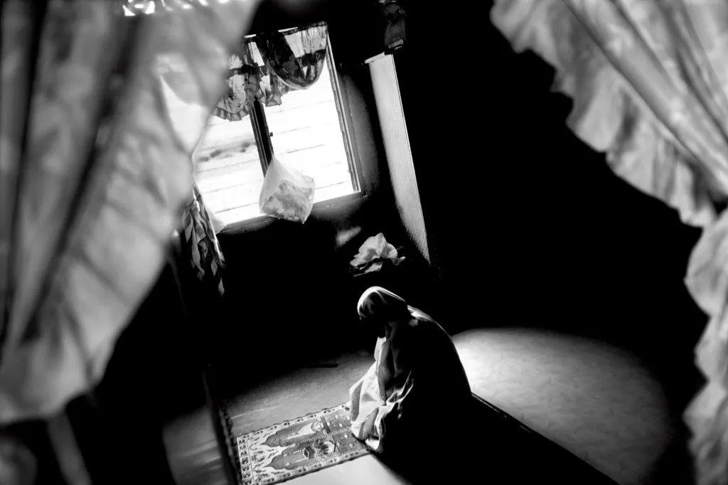 A Rohingya woman praying alone at home.
