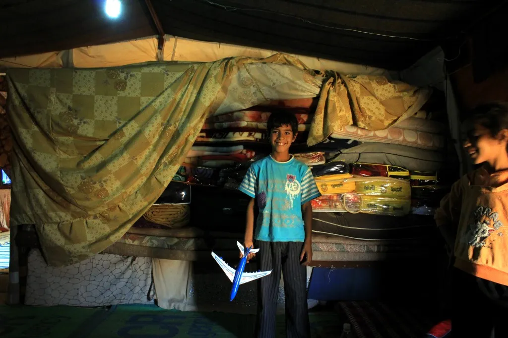 A boy stands with one of his favorite toys. (Credit: Lucas de Abreu, October 2014)