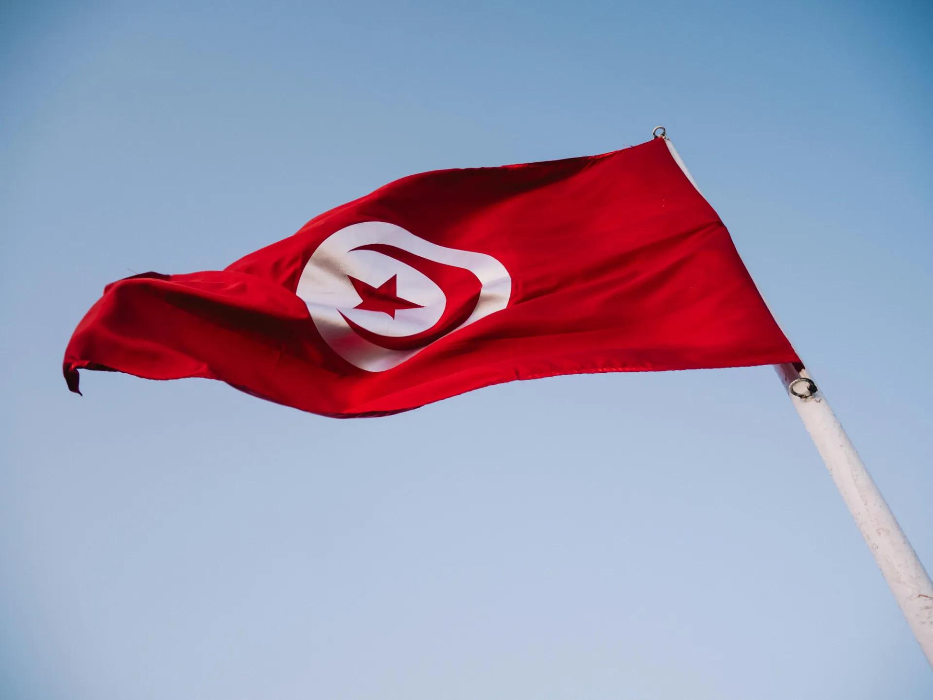 Flag of Tunisia against the backdrop of the sky.