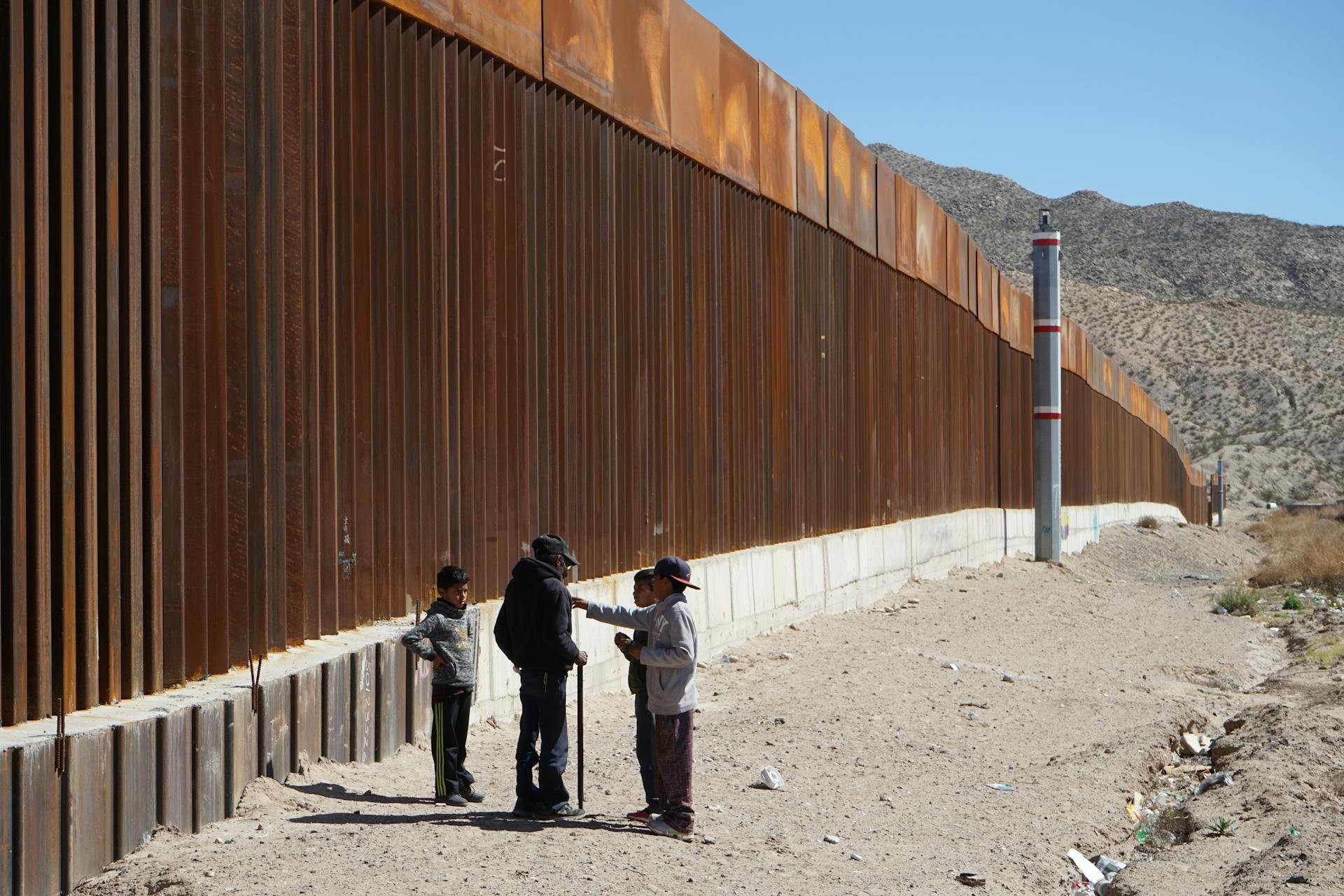 Children standing next to borderline wall. Photo by David Peinado. 